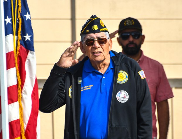 American Legion Chaplain Al Granados salutes during the National Anthem...
