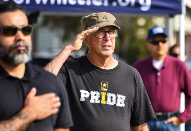 Army Veteran Bruce Hearn salutes during the National Anthem as...