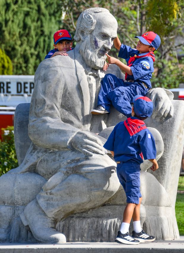 Cub Scouts climb on the statue of John Greenleaf Whittier...