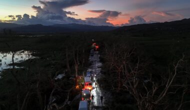 A convoy carrying aid to Black River, which was hit by Hurricane Melissa, makes its way through Holland Bamboo, Jamaica, on Wednesday, where downed trees and debris partially blocked roads.