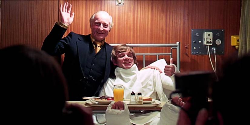 A still from the ending of A Clockwork Orange (1971), with Alex in a hospital bed posing for the press
