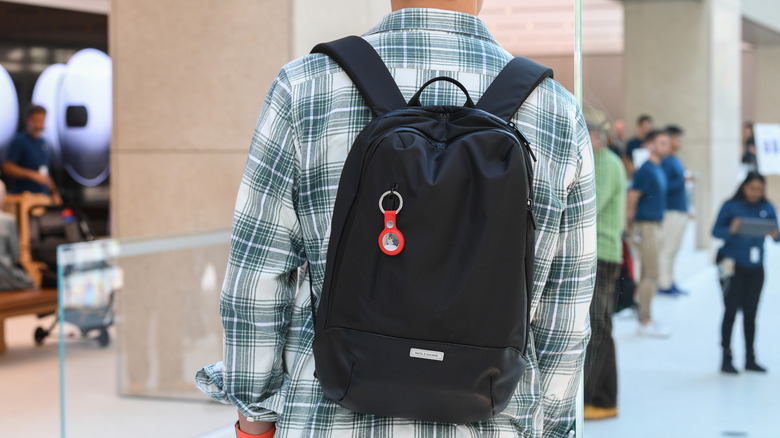 An AirTag hanging off of a person's backpack