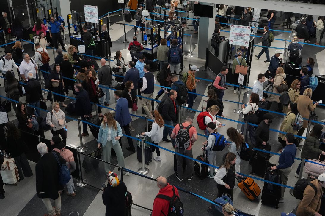Travelers wait at a security checkpoint at O'Hare International Airport in Chicago on Friday.