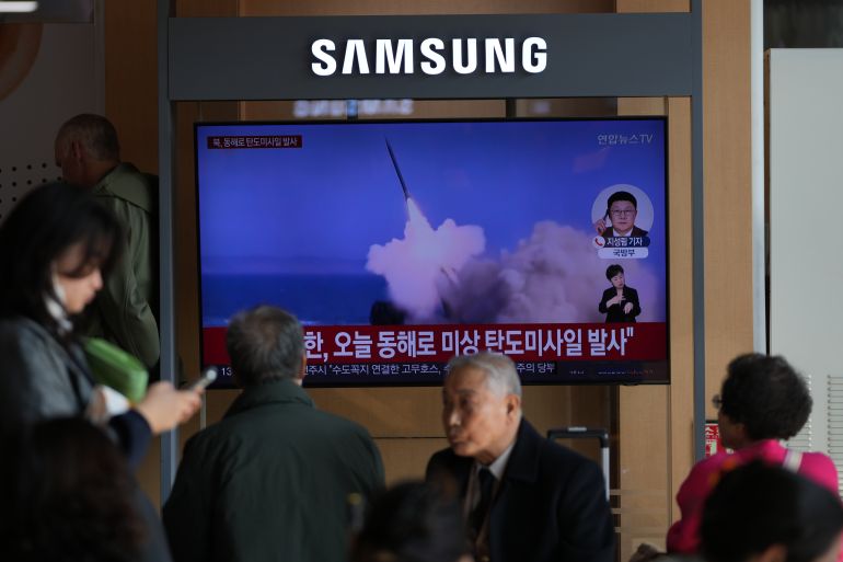 A TV screen shows footage of missiles.