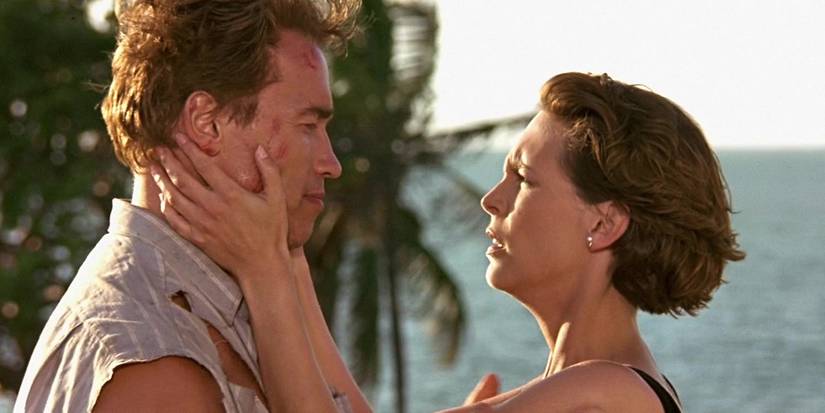Arnold Schwarzenegger as Harry Tasker and Jamie Lee Curtis as Helen Tasker on beach in True Lies