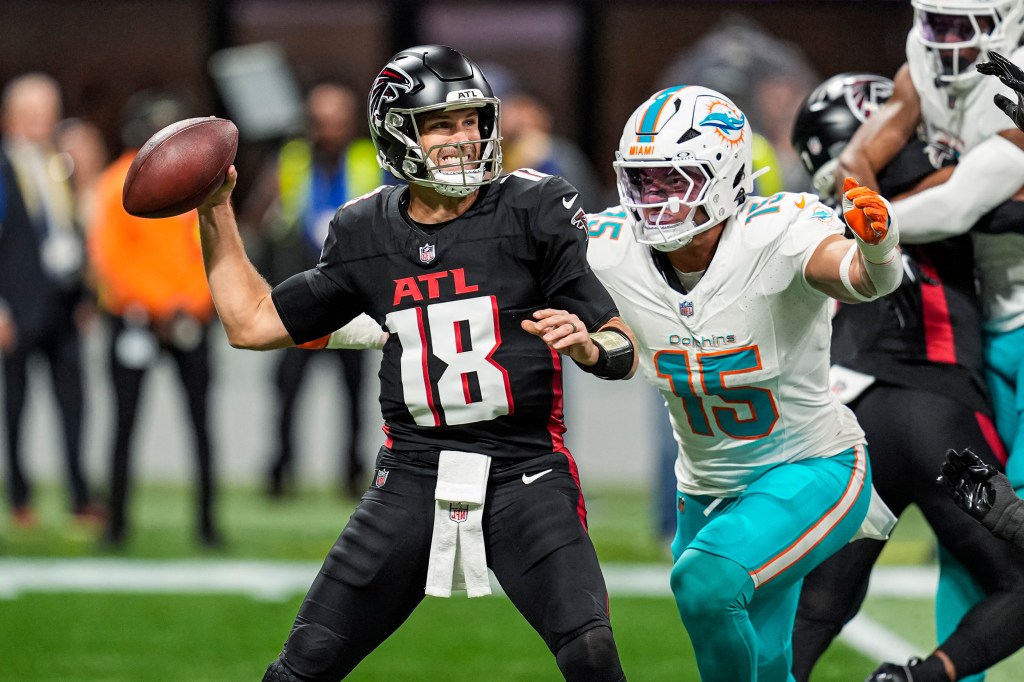 erback Kirk Cousins (18) passes under pressure from Miami Dolphins linebacker Jaelan Phillips (15) during the first quarter at Mercedes-Benz Stadium.