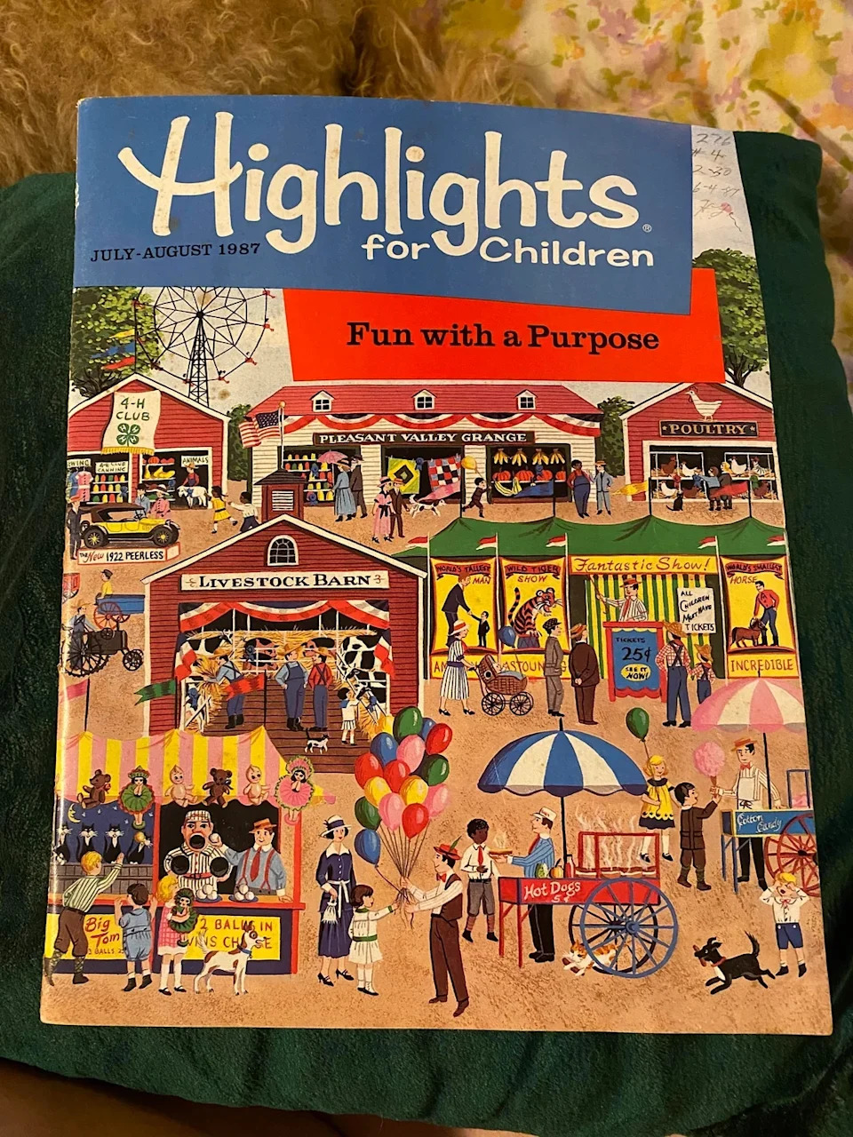 Cover of the July-August 1987 issue of "Highlights for Children" featuring a lively fair scene with various booths and a crowd