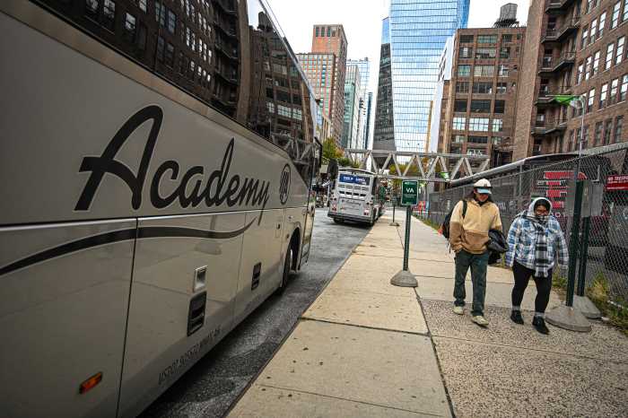 people walking on a sidewalk and a bus parked in the street