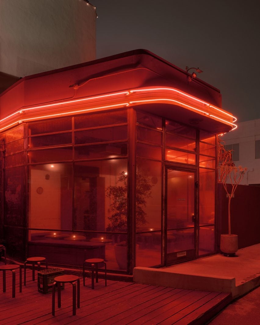 Red neon bands wrapped around the top of a building seen at night