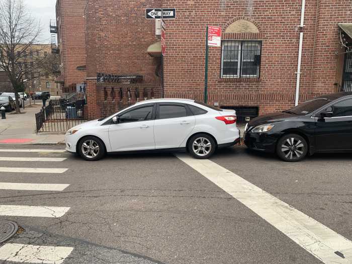 a white car parked in a crosswalk