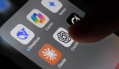A person's finger tapping a ChatGPT app icon on an iPhone screen that also shows icons for DeepSeek, Gemini, Copilot, Grok, and Claude.