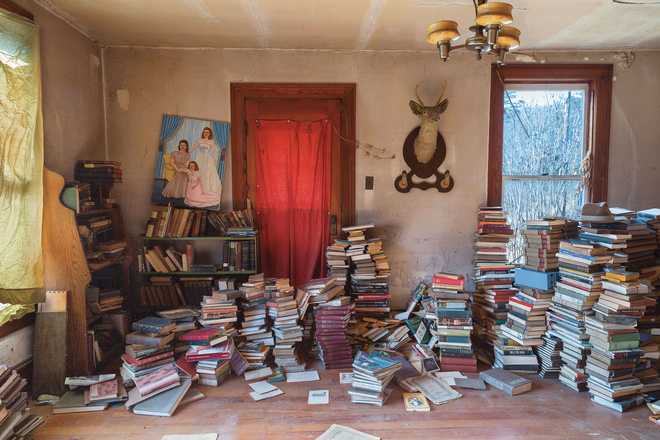 Books stacked high in the former home of an unnamed Pulitzer Prize-winning author in Preston County, West Virginia.