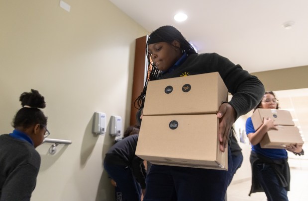Fifth grader Daniyah Barnett, 11, helps Sebastian White unload meal kits delivered to students, Nov. 20, 2025, at the Jesuit Academy of Chicago. (Dominic Di Palermo/Chicago Tribune)