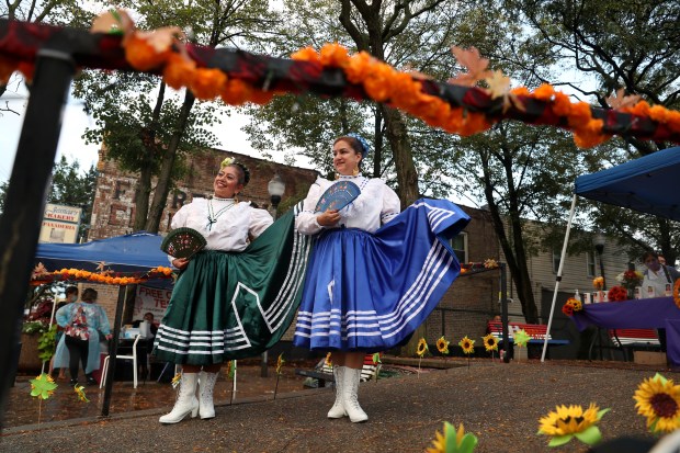 Isabel Garcia, left, and Sylvia Larco, part of the Quetzal-Xochitl Mexican folkloric dance group, stand in Manuel Perez Jr. Plaza in Chicago's Little Village neighborhood Oct. 8, 2021. Choose Chicago provided funding for the plaza's renovation. (Chris Sweda/Chicago Tribune)