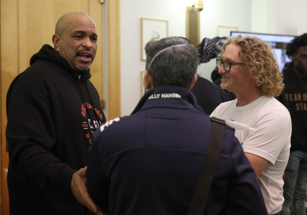 Chicago Race Riot of 1919 Commemoration Project co-directors Franklin Cosey-Gay, left, and Peter Cole, right, speak with an attendee of a panel discussion about the project at the Harold Washington Library, Nov. 8, 2025, in Chicago. (John J. Kim/Chicago Tribune)