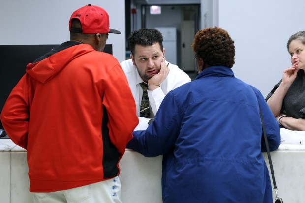 Taxpayer service representative Mustafa Abdul Maboud, center, helps people with property tax issues at the Cook County Treasurer's office in downtown Chicago on Nov. 14, 2025. (Terrence Antonio James/Chicago Tribune)