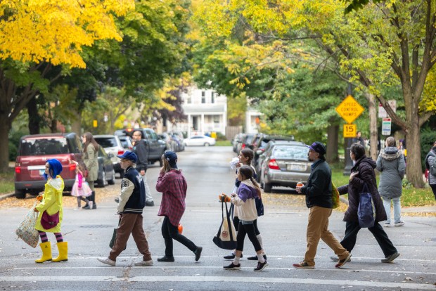 Kids and parents trick-or-treat on Monroe Street in Evanston on Oct. 31, 2025. (Dominic Di Palermo/Chicago Tribune)