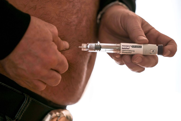 A close up view of a man using the weight loss injection Mounjaro on his belly.