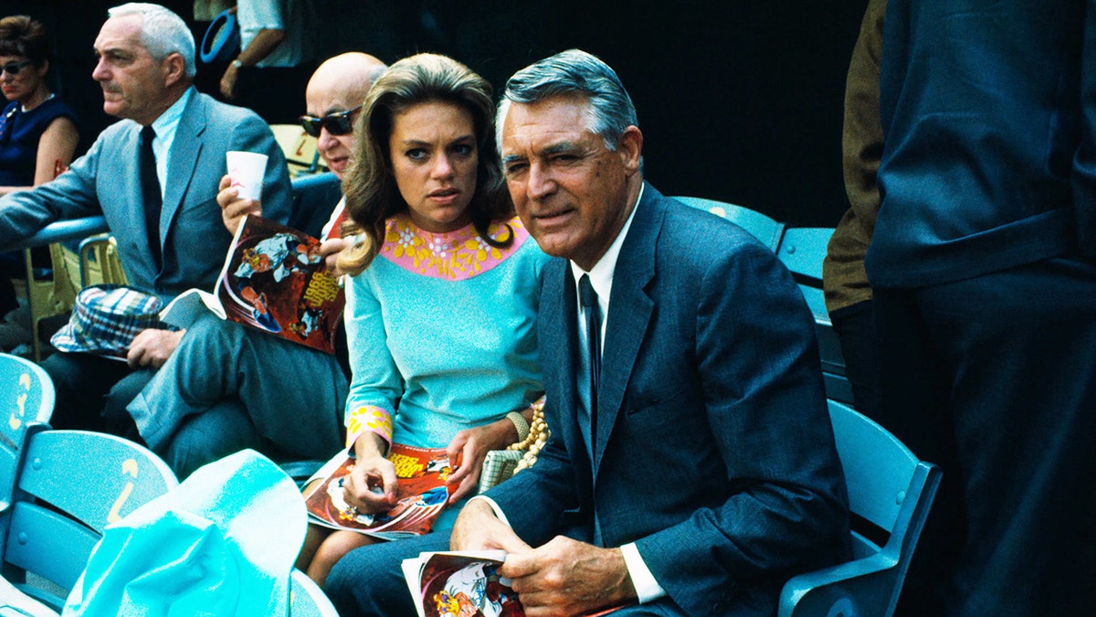Dyan Cannon and Cary Grant looking at game with serious expressions on their faces.