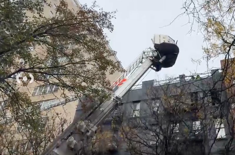 Firefighters on an extended ladder and building roof during an Upper East Side apartment fire.