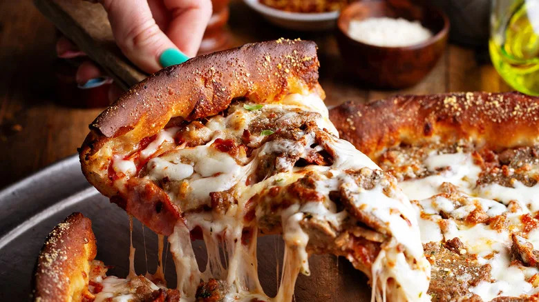 Hand serving pizza slice