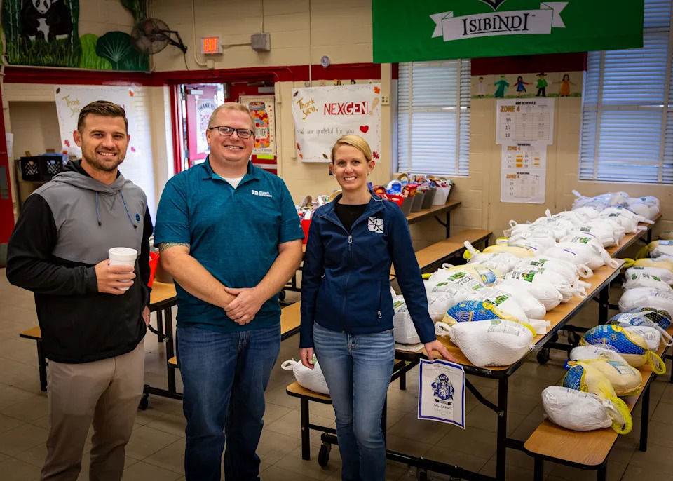 Tim Betros, CEO/founder, NexGen Roofing, from left; Adam Russell, executive vice president, Russell Rowland Inc.; and Jackie Rowland, president/CEO of Russell Rowland; take a break during a San Jose Elementary delivery for their two companies' Thanksgiving food drives.