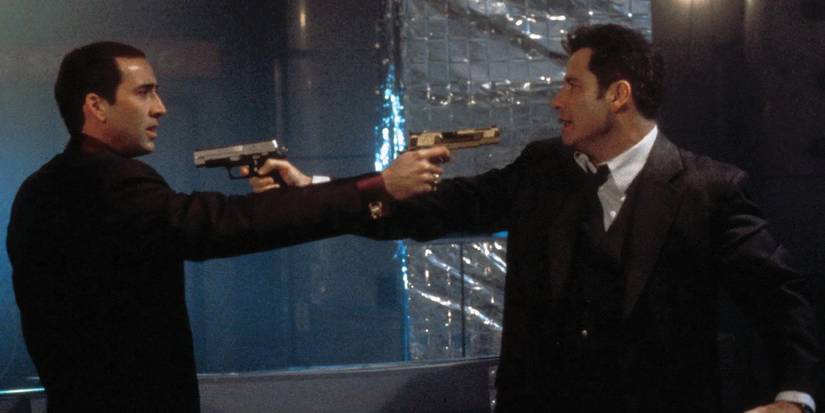 Nicolas Cage and John Travolta point guns at one another in Face/Off.