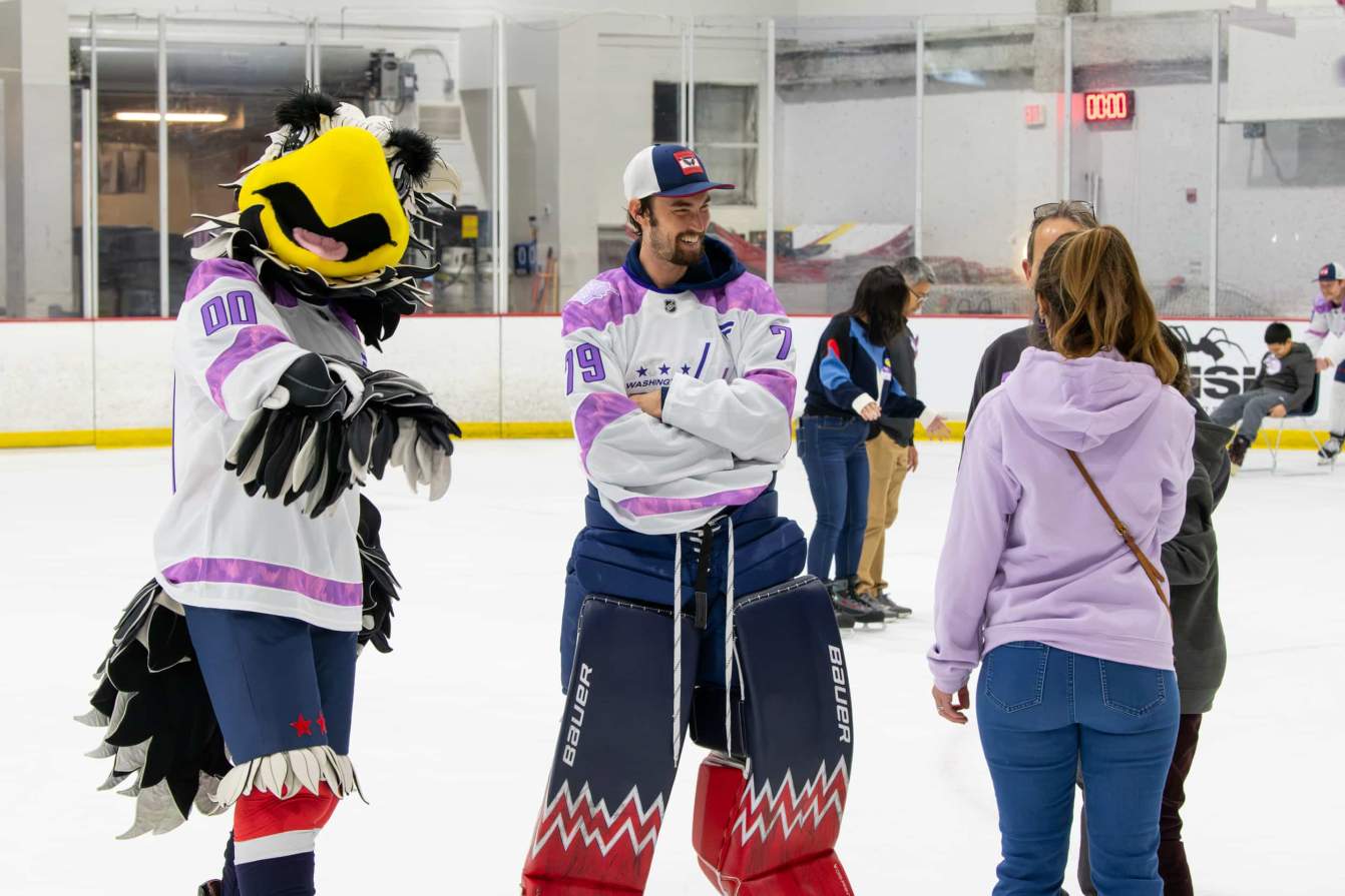 Charlie Lindgren, Slapshot, and family members on the ice during the Hockey Fights Cancer skate.