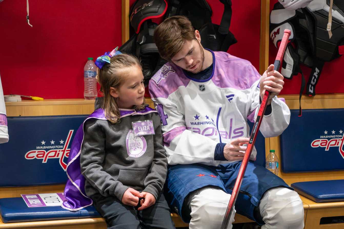 Connor McMichael and Eliza in the locker room before the Hockey Fights Cancer skate.