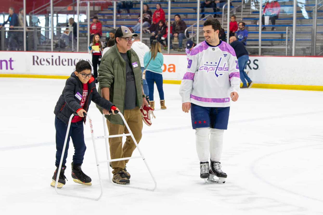Hendrix Lapierre, David, and a family member on the ice during the Hockey Fights Cancer skate.