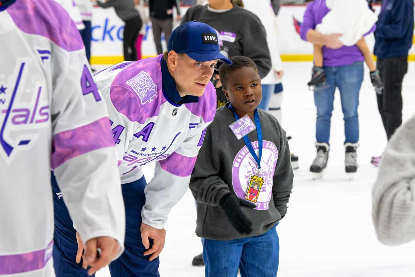 John Carlson and Bryson on the ice during the Hockey Fights Cancer skate.