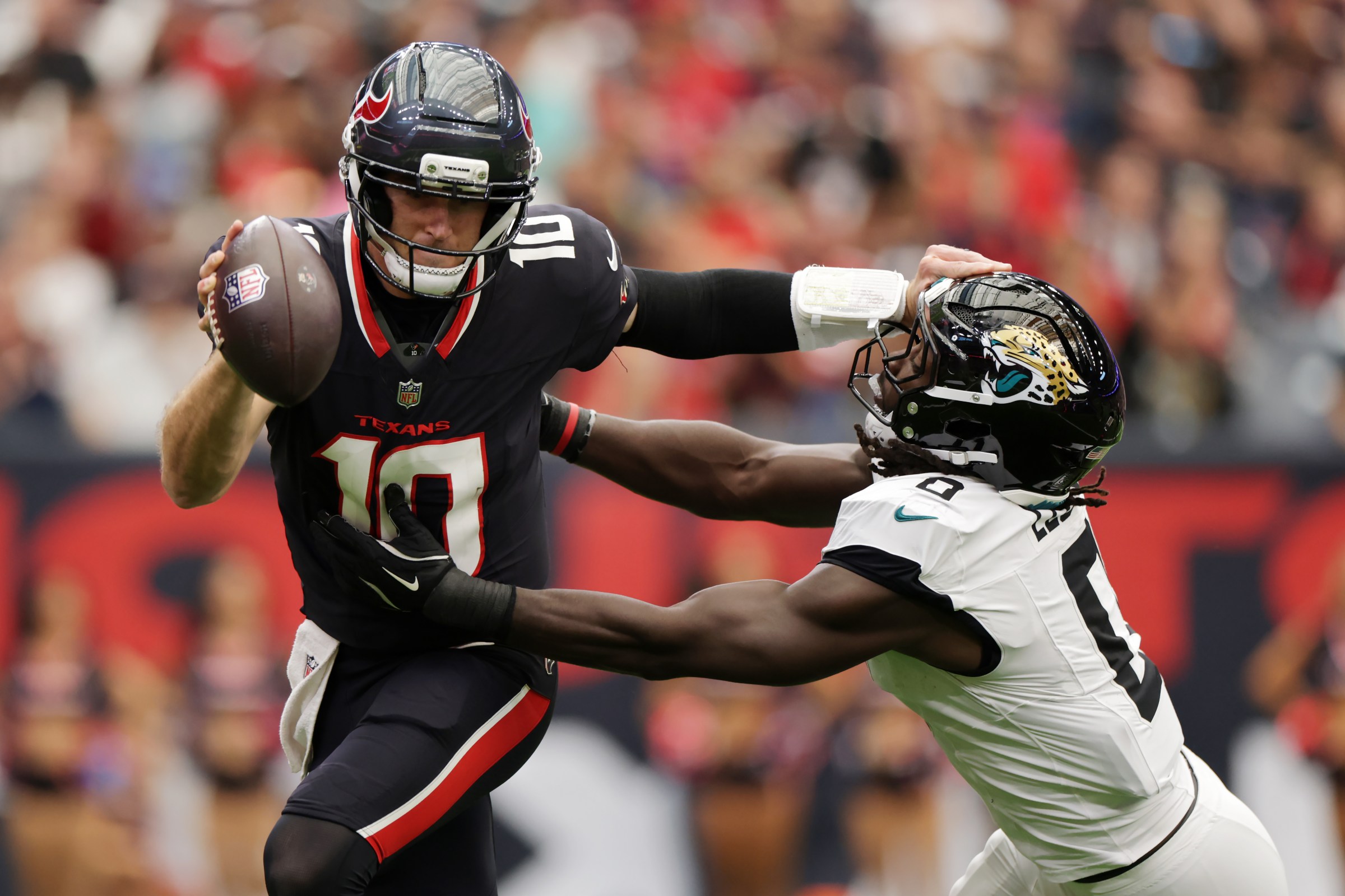 HOUSTON, TEXAS - NOVEMBER 09: Davis Mills #10 of the Houston Texans carries the ball against Devin Lloyd #0 of the Jacksonville Jaguars during the first half in the game at NRG Stadium on November 09, 2025 in Houston, Texas. (Photo by Kenneth Richmond/Getty Images)