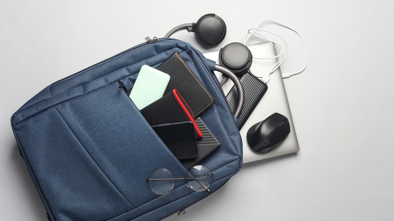 A bunch of tech gadgets with a backpack