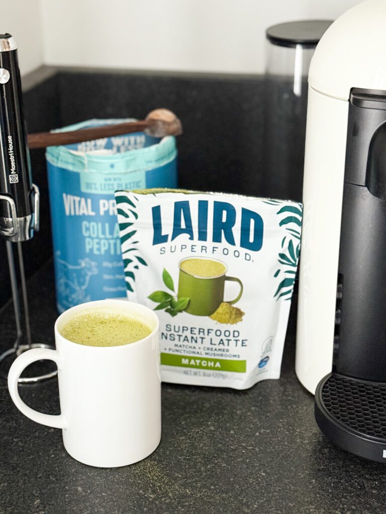 Tub of Vital Proteins collagen powder sitting next to a mug of Laird Superfood matcha.