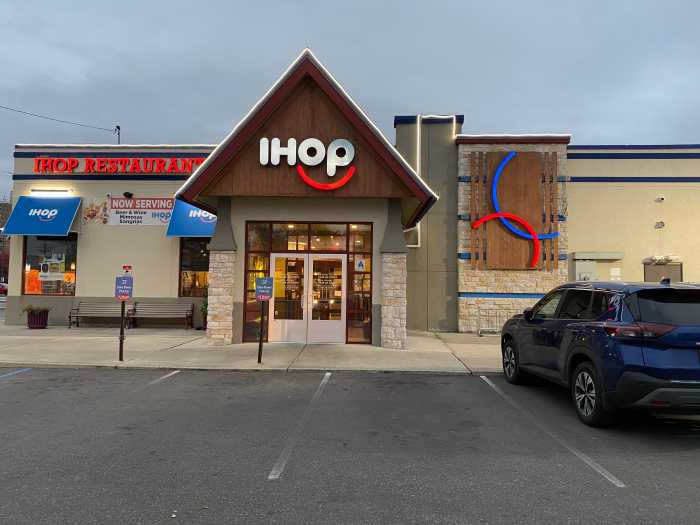 outside of a restaurant with a car parked in front