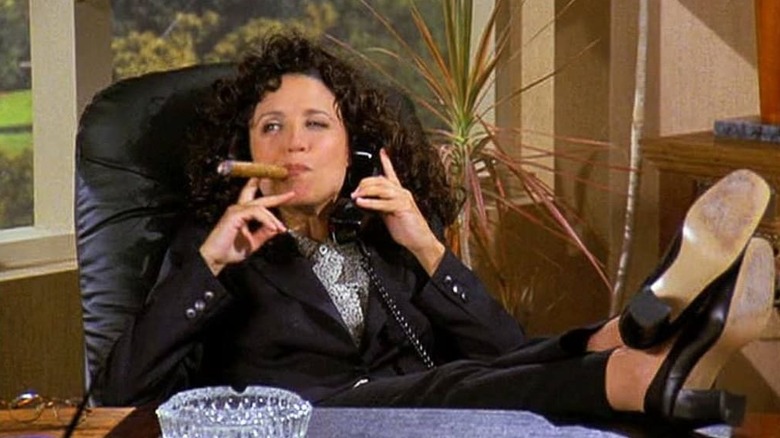Elaine Benes (Julia Louis-Dreyfus) smokes a cigar on Seinfeld