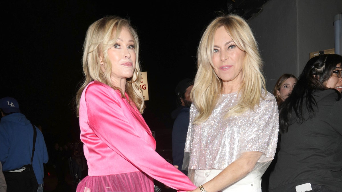 Sutton Stracke and Kathy Hilton hold hands