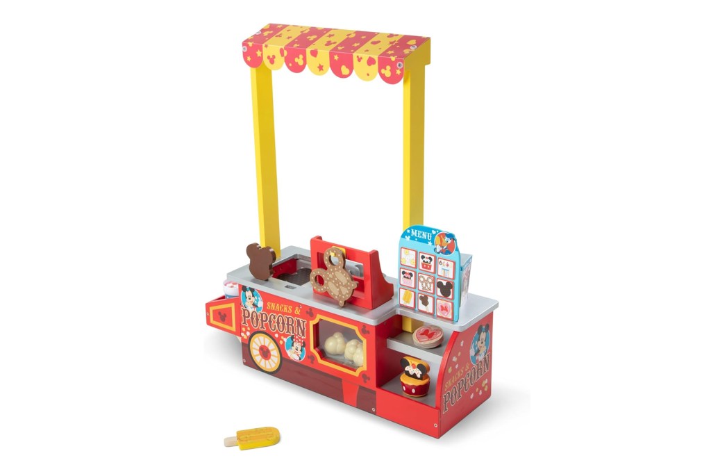 A toy food stand with a yellow and red canopy