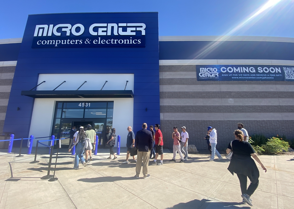 People lined up outside the entrance of a Micro Center store.