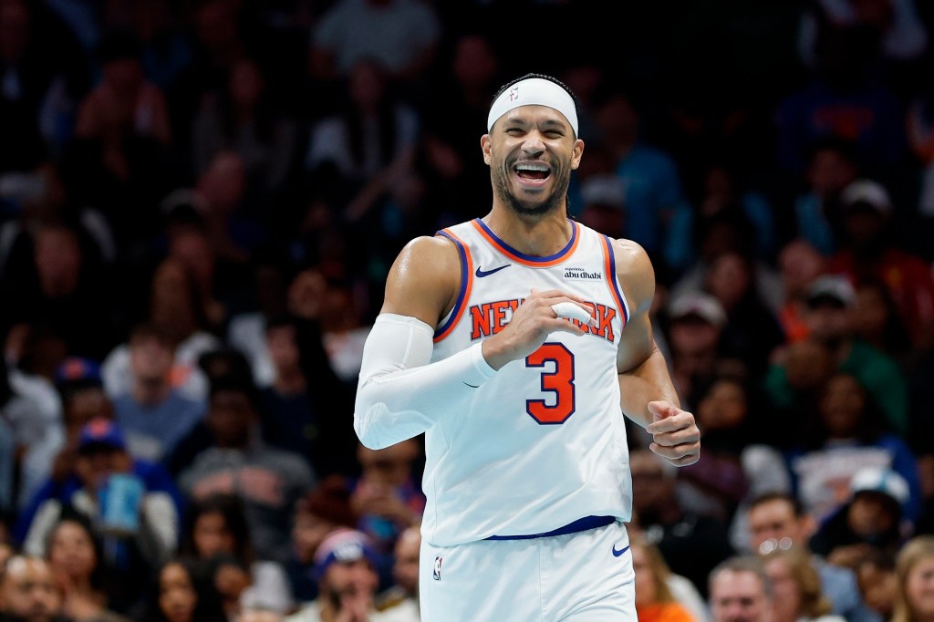 New York Knicks guard Josh Hart laughs while running down the court.