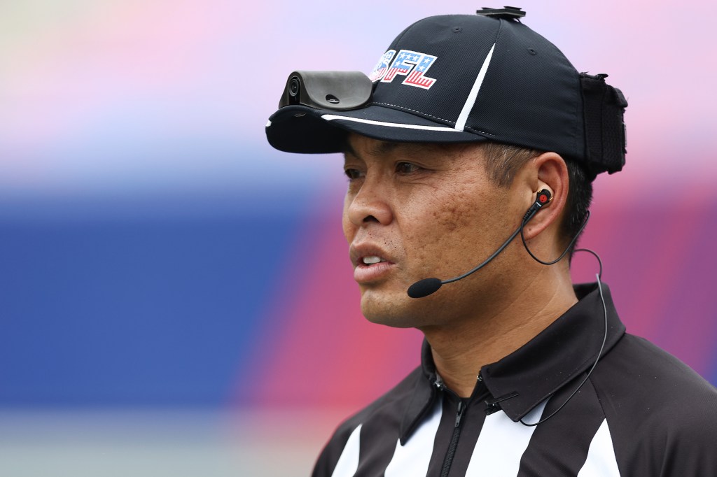 A referee wearing a baseball cap with a camera and a microphone headset.