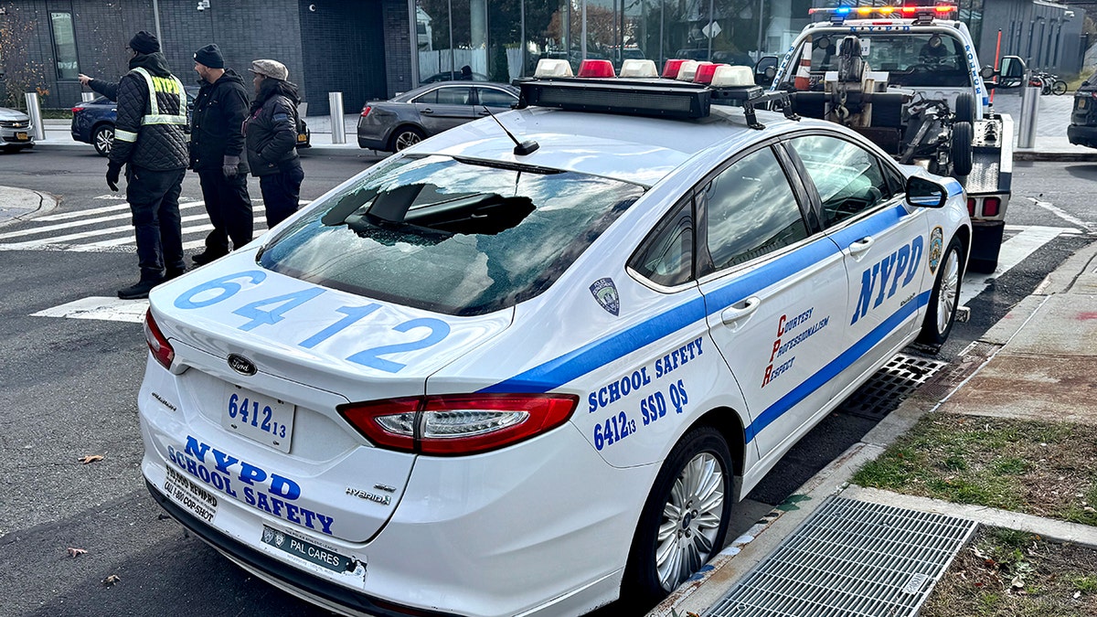 NYPD patrol car with broken back window being towed 