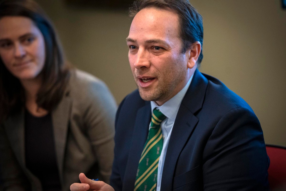 A man in a suit and tie sitting at a table.