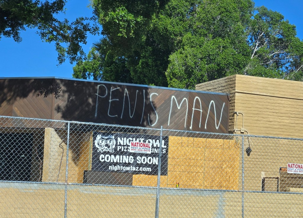 A vacant restaurant with the words "PENIS MAN" spray-painted on it.