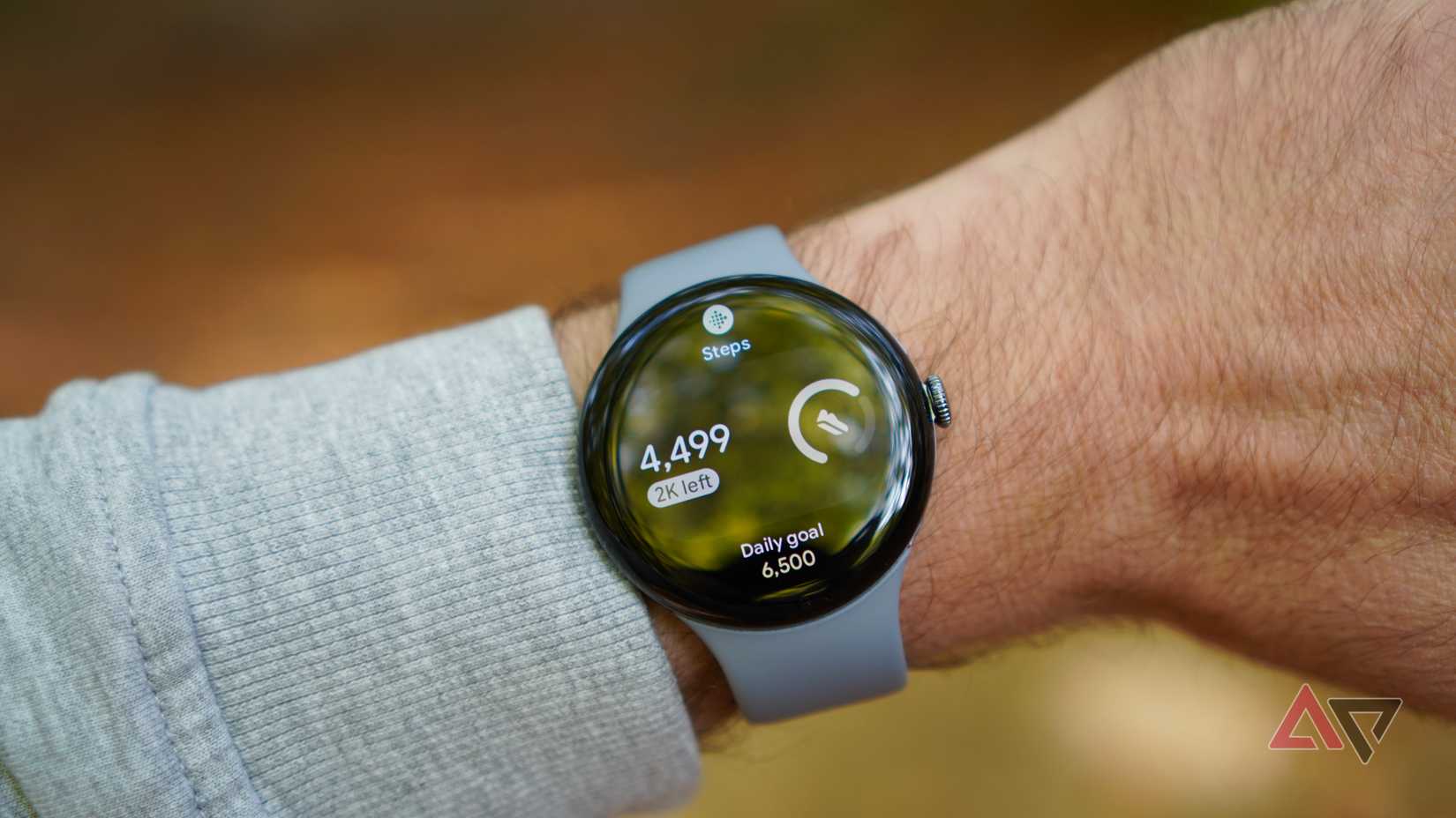 The Google Pixel Watch 4 showing a step counter on the watch face