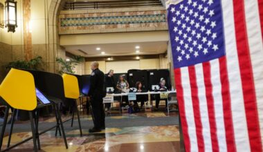 Workers wait for voters to arrive at a polling station on Tuesday in Los Angeles. (AP Photo/Ethan Swope)