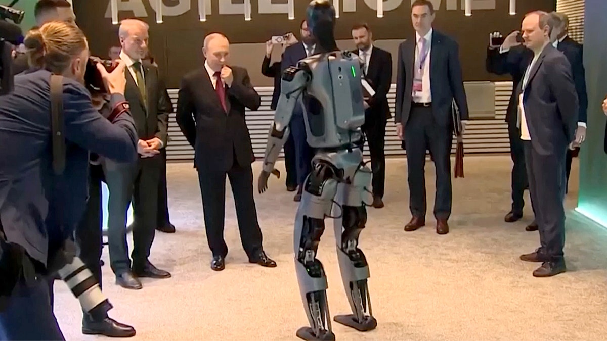 Putin surrounded by bodyguards as the robot dances. 
