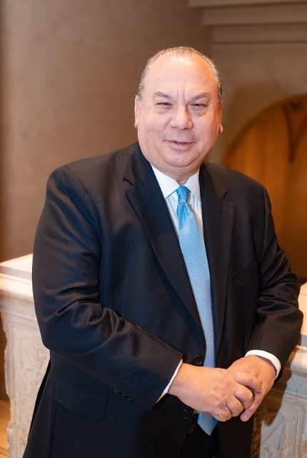 man wearing dark-colored suit and a blue tie