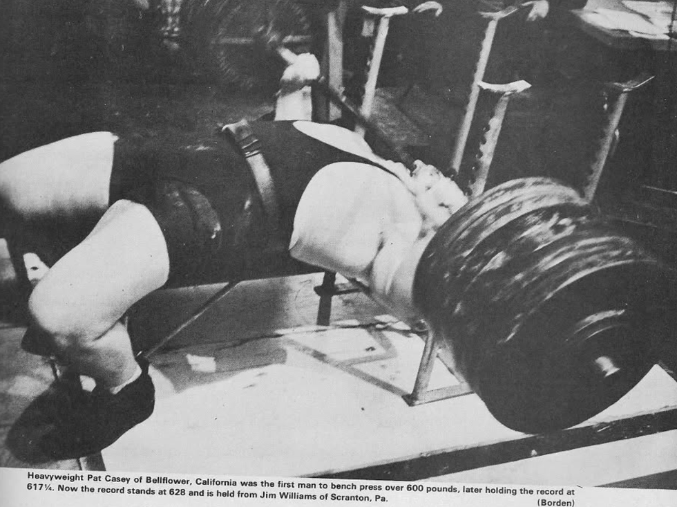 a man performing a bench press with a heavy barbell highlighting strength training