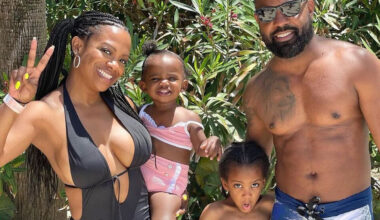 Kandi Burruss gives a peace sign in an Instagram photo wearing a bikini with her husband Todd Tucker and children Blaze and Ace